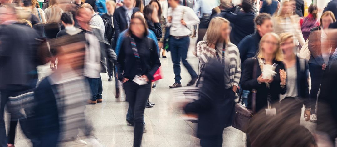 Aufnahme einer Straße mit vielen Menschen, niemand ist erkennbar, manche Menschen im Vordergrund unscharf