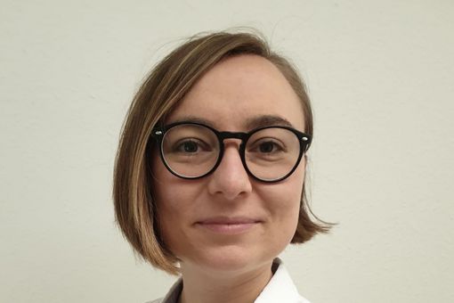 Bild von Laura Hommers vor einer weißen Hauswand.